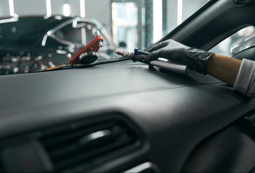 Man inside car repairing windshield