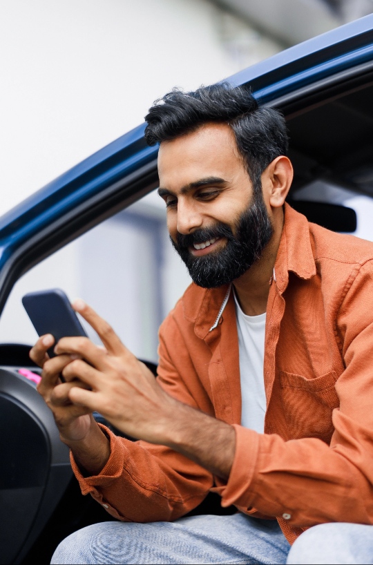 Man sitting car and holding phone with two hands