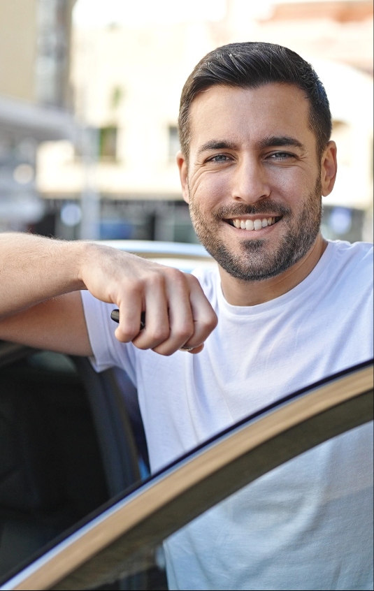 Man smiling and entering vehicle