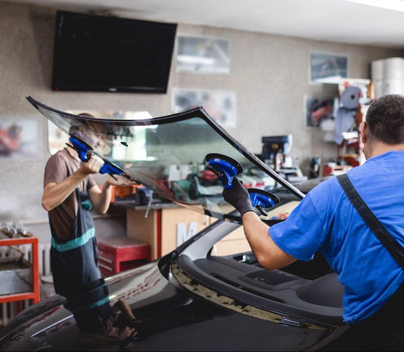 Men changing windshield vehicle