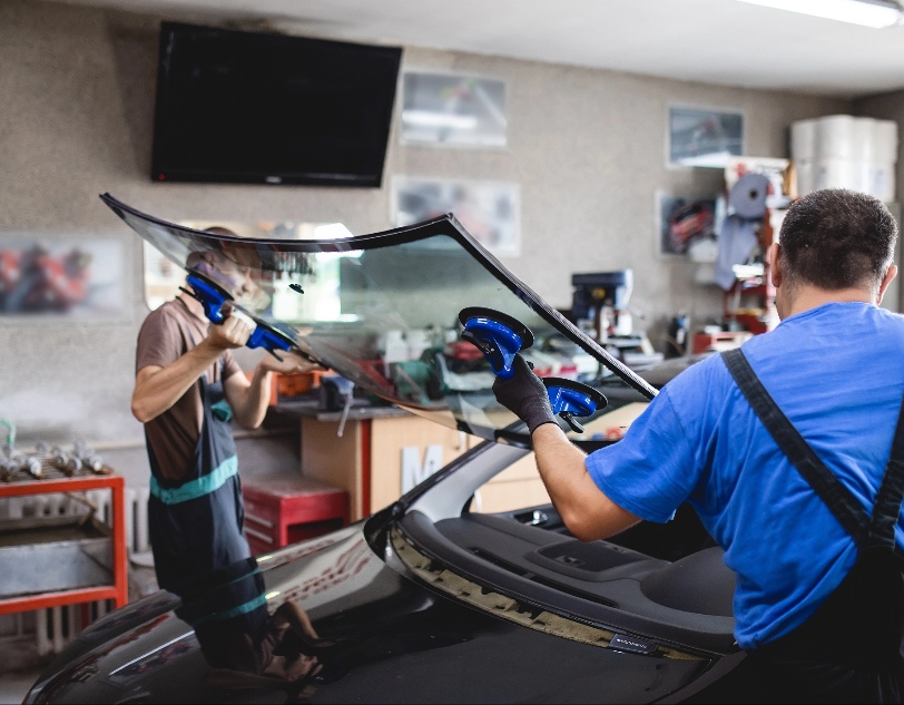 Two men replacing windshield