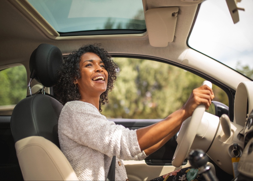 Woman driving car sunny day