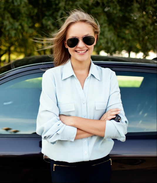 Woman wearing sunglasses next to car